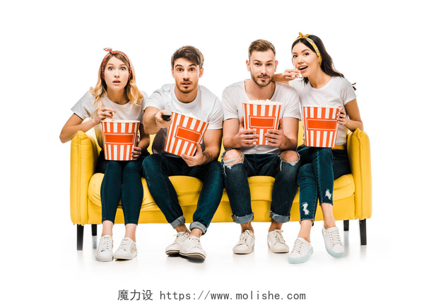 白色背景下的一个黄色沙发上坐着四个年轻人年轻的朋友拿着爆米花盒和看电视, 而坐在黄色沙发上孤立的白色  